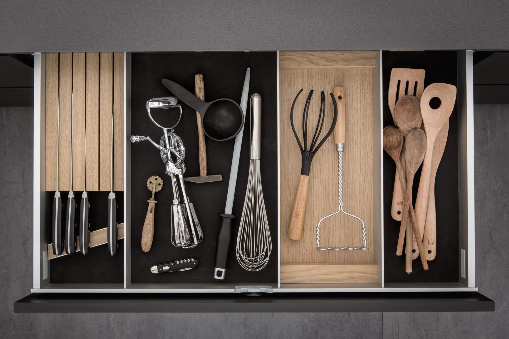 SieMatic - dark smoked cheshunt and light oak lining and moveable aluminium panels with utensils